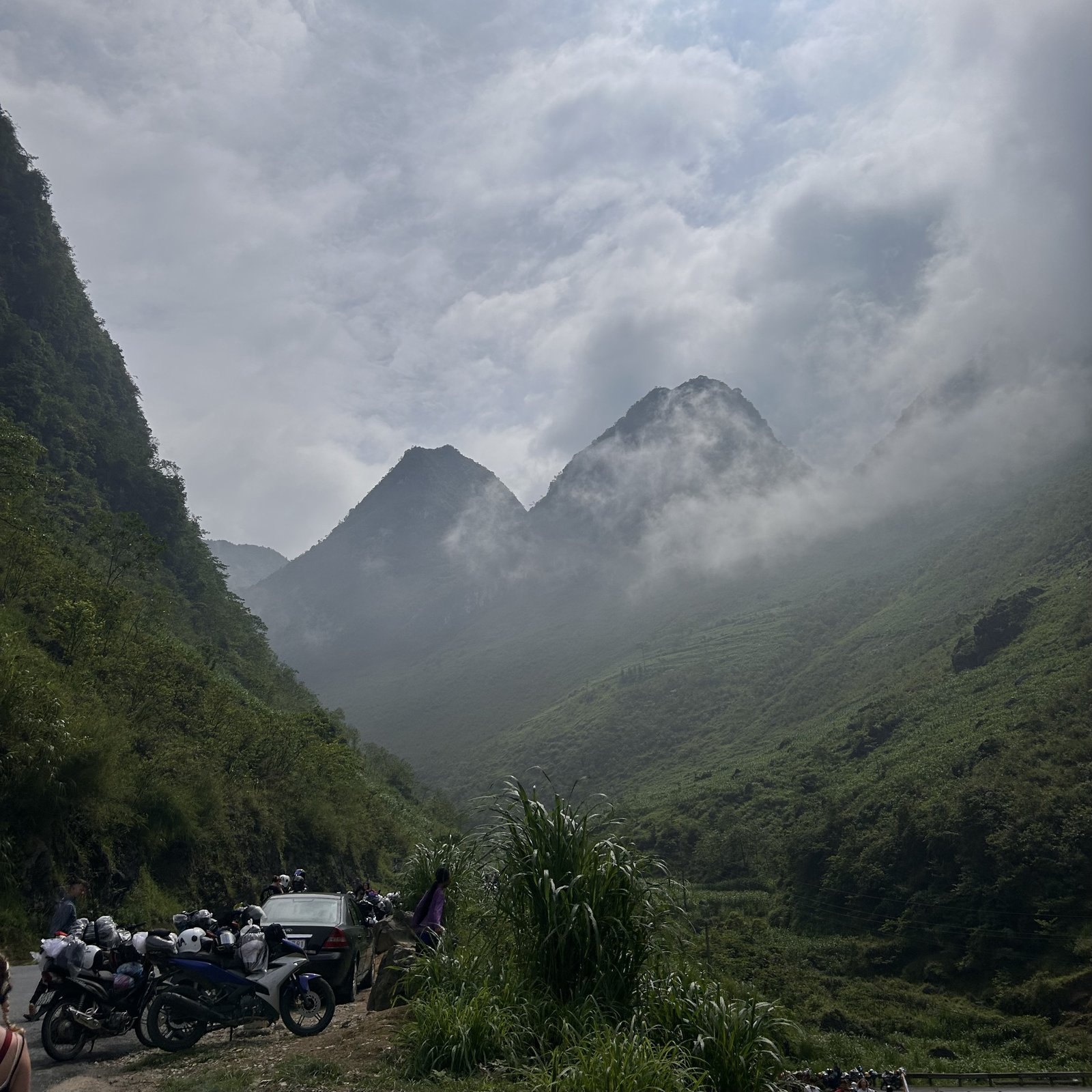 Motorbikes parked overlooking misty green mountains near the Vietnam-China border